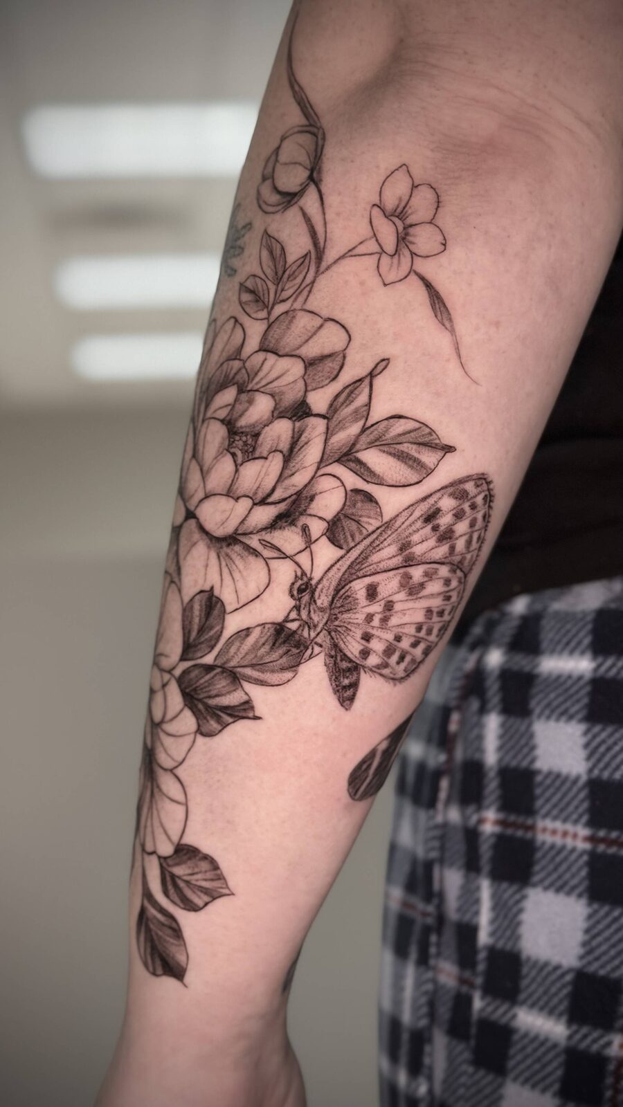 Floral and butterfly forearm tattoo