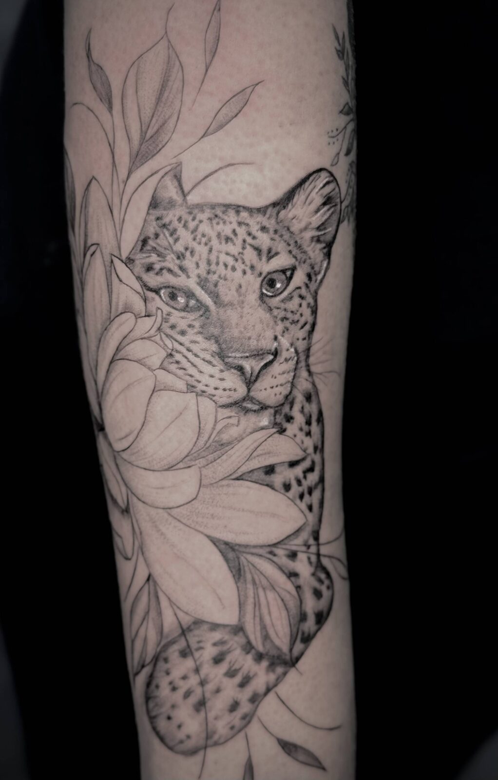 Fine line leopard and peony forearm tattoo