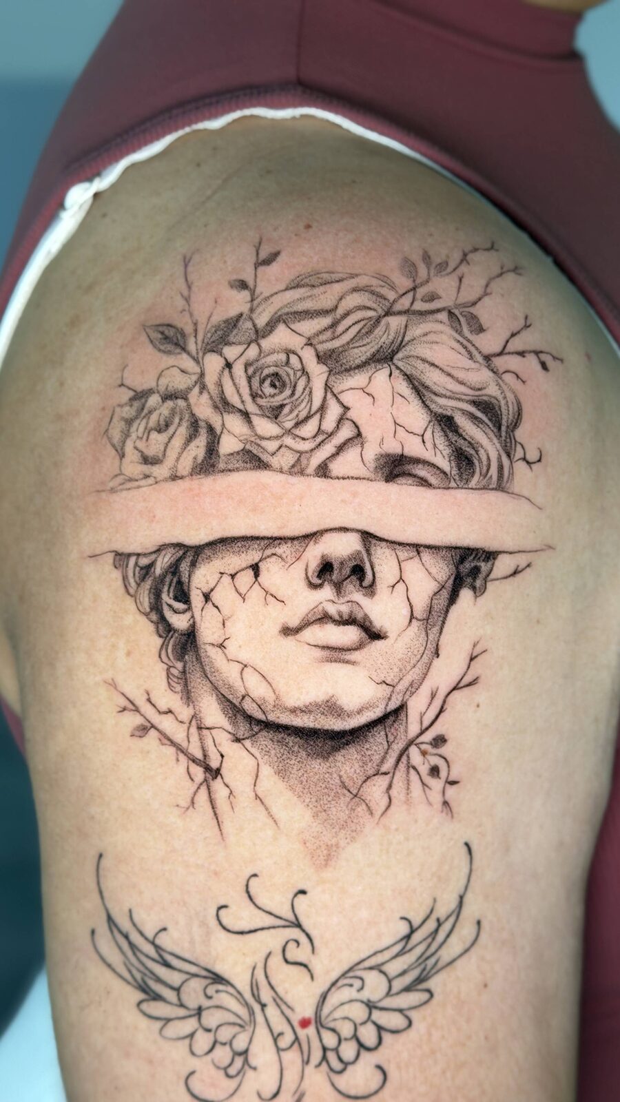 Graphic realism statue tattoo with flowers, black and grey