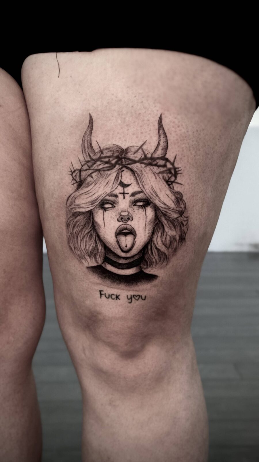 Illustrative horned girl tattoo on a thigh