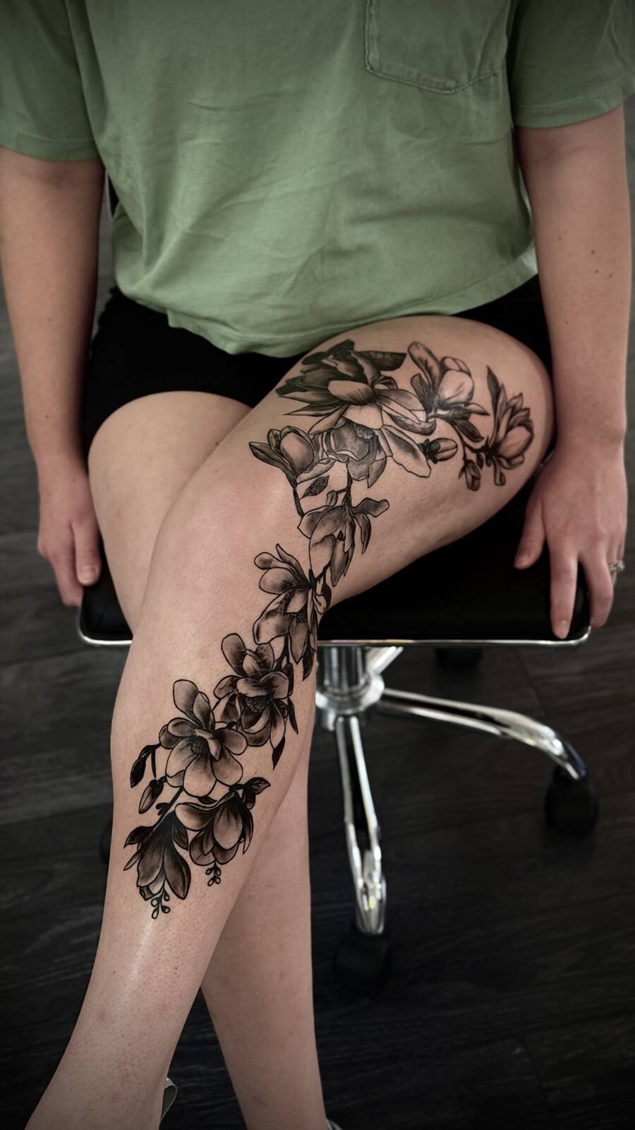 Black floral tattoo wrapping around a leg